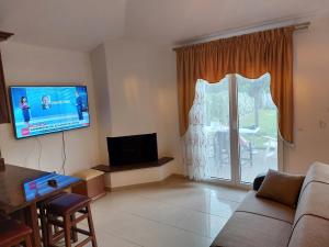 un soggiorno con divano e TV a schermo piatto di Μονοκατοικία a Nafpaktos