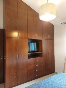 - une chambre avec une grande armoire en bois et une télévision dans l'établissement Μονοκατοικία, à Naupacte