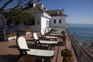 una fila di sedie su un balcone con vista sull'oceano di Hostal Mar de Frente a Los Caños de Meca