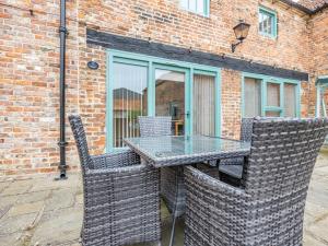 a glass table and chairs on a patio at The Hayloft - Uk44519 in Tetney