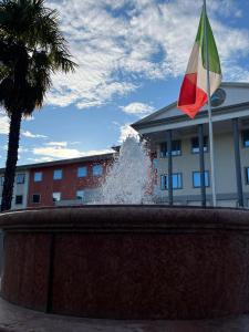 a fountain with a flag in front of a building at Hotel Poppi in Mira
