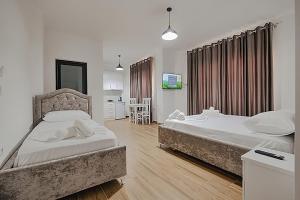 a bedroom with two beds and a table and chairs at Vila Muka in Ksamil