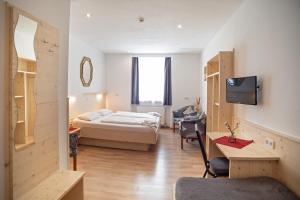 Habitación con 1 dormitorio con 1 cama y TV. en Hotel Gisela en Kufstein