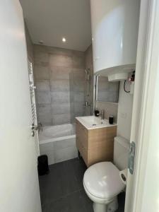 La salle de bains est pourvue de toilettes, d'un lavabo et d'une baignoire. dans l'établissement Petite échoppe Bordeaux, à Bègles