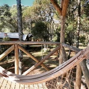 een hangmat voor een houten hek bij Cabanas dos Pinheiros in São Francisco de Paula