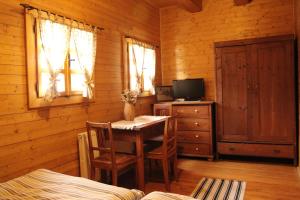 ein Esszimmer mit einem Tisch und einem TV in einer Hütte in der Unterkunft Drevenica in Oščadnica