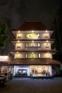 un edificio alto con un letrero iluminado en Cipta Hotel Wahid Hasyim en Yakarta
