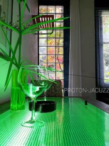 un tavolo verde con un bicchiere di vino sopra di zentral club apartamento protón-jacuzzi a Belmonte de Miranda