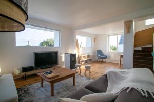 uma sala de estar com um sofá e uma televisão em Ty Meham, à 700m de la plage et Meneham, grand terrain calme em Kerlouan
