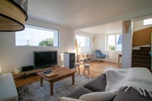 a living room with a couch and a tv at Ty Meham, à 700m de la plage et Meneham, grand terrain calme in Kerlouan