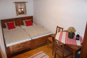 ein kleines Schlafzimmer mit einem Bett und einem Tisch in der Unterkunft Drevenica in Oščadnica