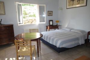 1 dormitorio con cama, mesa y ventana en Chambre d'hôtes au temps des cerises, en Pierrefeu-du-Var