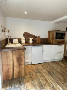 a kitchen with white cabinets and a wooden floor at Le Relais des galets in Domme