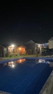 a swimming pool at night with a house at Островок in Pizunda