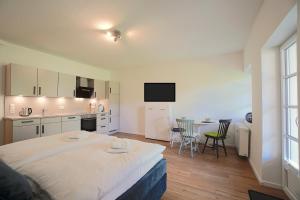 a bedroom with a large bed and a kitchen at Ferienwohnung Lütt Stuv in Schleswig