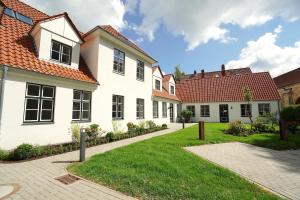 a row of white houses with red roofs at Ferienwohnung Lütt Stuv in Schleswig +11 photos