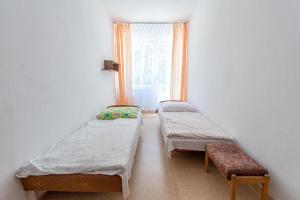 two beds in a room with a window at OKW Bursztyn Międzywodzie in Międzywodzie