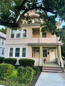 a yellow house with a tree in front of it at Boston Luxury 2 Bedroom Private Condo in Boston