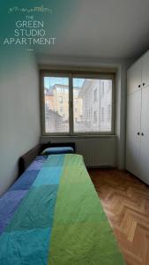 Un dormitorio con una cama con una manta de colores. en Green Studio Apartment, en Sarajevo