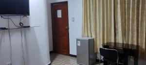 a room with a table and a television and a door at Makasai Tambopata 3 in Puerto Maldonado