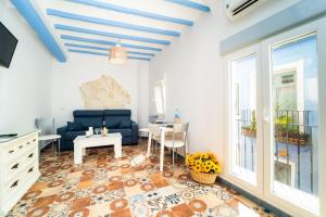 een woonkamer met een blauwe bank en een tafel bij Alhambra Dreams 1958 in Villajoyosa