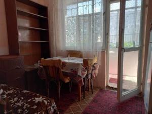 a room with a table with chairs and a window at Vintage Vibes - Family Flat in a Quiet Area in Sliven