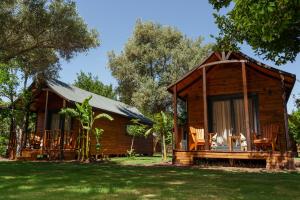 a log cabin with a porch and chairs in the yard at Dolce Vita Luxury Bungalows in Bodrum City