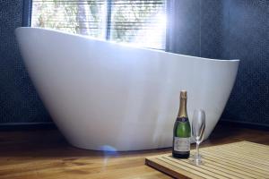 a bottle of champagne sitting next to a wine glass at The Beeches Olinda Accommodation in Olinda