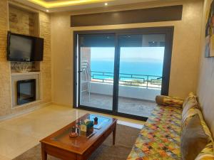 - un salon avec un canapé et une vue sur l'océan dans l'établissement Ghougine Serenity Residence Bis, à Tanger