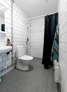 a white bathroom with a toilet and a sink at Communia Hotel Residence in Stockholm