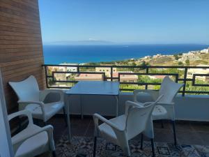 d'un balcon avec une table et des chaises donnant sur l'océan. dans l'établissement Ghougine Serenity Residence Bis, à Tanger