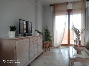 sala de estar con TV en la parte superior de un tocador en Nueces y Horkillas Novo Sancti Petri, en Chiclana de la Frontera