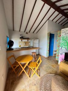 uma cozinha com mesa e cadeiras num quarto em Chales Barra Grande em Barra Grande