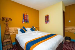 a bedroom with a large bed with yellow walls at Kwabahal Boutique Hostel in Kathmandu