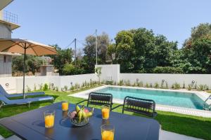 a table with a bowl of fruit next to a swimming pool at Green Villa in Ialysos