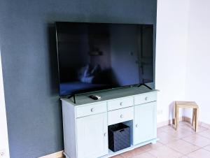 a flat screen tv sitting on top of a white cabinet at Ferienwohnung Blütenzauber in Idyllischer Lage Nähe Bodensee in Hilzingen