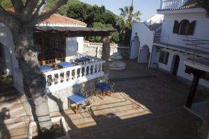 a patio with chairs and a tree next to a building at Hostal Mar de Frente in Los Caños de Meca