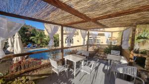 un patio con mesa, sillas y piscina en Villa Serenity B&B, en Sannat