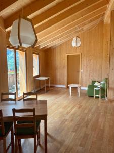 Großes Zimmer mit Holzwänden, einem Tisch und Stühlen in der Unterkunft BerglandHof Hotel Ernen in Ernen