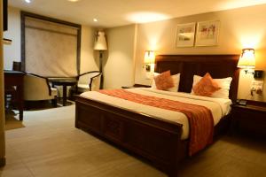 um quarto de hotel com uma cama grande e uma secretária em Hotel Sai Inn em Mumbai