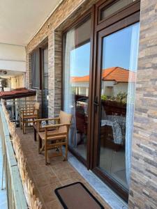 a balcony with sliding glass doors and a table and chairs at HIPPOCAMPUS APARTMENT in Stratónion