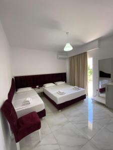 um quarto de hotel com duas camas e uma cadeira em Eraldo's Rooms and Apartments em Sarandë