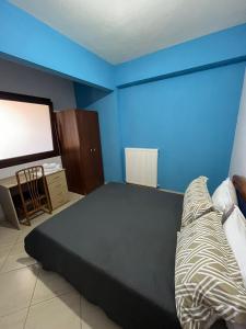 a bedroom with a bed and a large screen tv at HIPPOCAMPUS APARTMENT in Stratoni