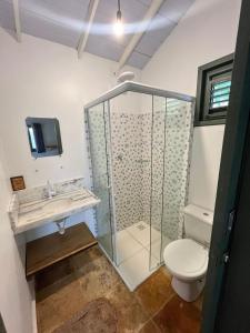 uma casa de banho com uma cabina de duche em vidro e um WC. em Chales Barra Grande em Barra Grande
