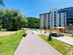 a park with a playground in front of a building at Sunny apartment в ЖК Сонячний Квартал in Golubinoye
