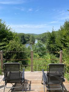 two chairs on a deck with a view of a river at Le Relais des galets in Domme