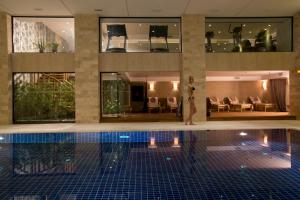 a man standing next to a swimming pool in a building at Miracle Istanbul Asia Airport Hotel & Spa in Istanbul