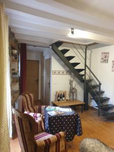 a living room with two chairs and a staircase at La Petite Chapelle in Font-Romeu