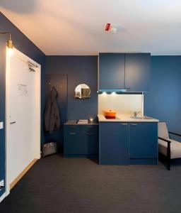 a kitchen with blue cabinets and a sink at Communia Hotel Residence in Stockholm