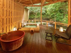 a large tub sitting on a wooden deck with a hot tub at Mizumari in Kawazu